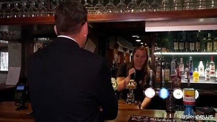 Burnham festeggia il taglio delle tasse al pub con birra in mano